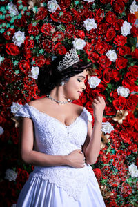 Bride standing against flowers 