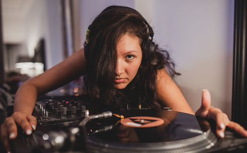 Close-up of fashionable young woman playing music at home