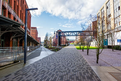 Walkway in city against sky