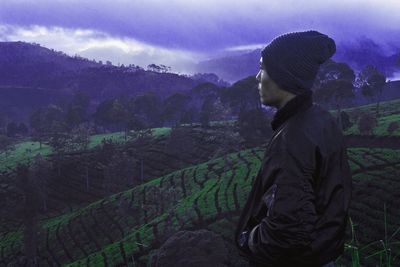 Side view of man looking at field