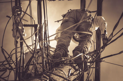 Directly below shot of worker standing on power lines