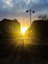 Road by city against sky during sunset