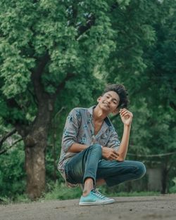 Full length portrait of young men sitting on land