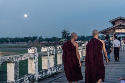 People standing by buildings against sky