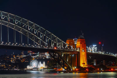 Illuminated bridge over river at night