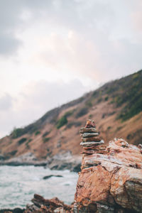 Stack of rocks on mountain against sky