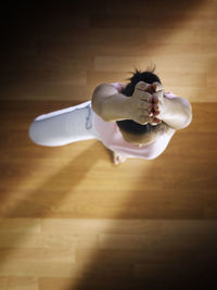 Young woman wearing mask on hardwood floor