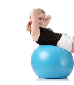 Young woman with ball in hair against white background