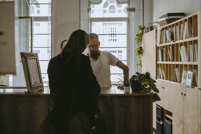 Businessman discussing with female colleague over table at office