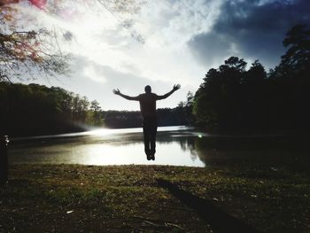 Silhouette of woman jumping in water