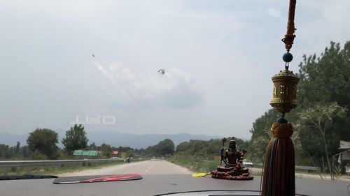 Cars on road against sky in city