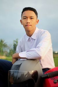 Portrait of young man standing in car