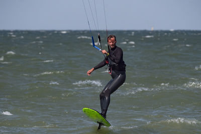 Rear view of woman jumping in sea