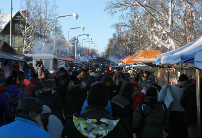 Crowd in city against sky