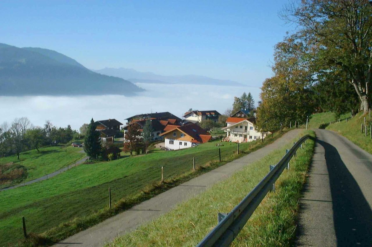 building exterior, architecture, built structure, mountain, house, tree, sky, landscape, grass, residential structure, road, town, blue, nature, green color, day, village, high angle view, tranquil scene, residential building