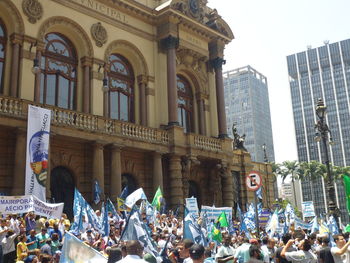 Crowd in city against sky