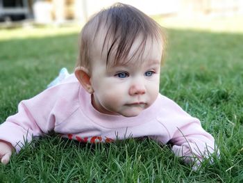 Portrait of cute baby girl on field