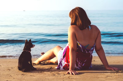 Rear view of man sitting on beach