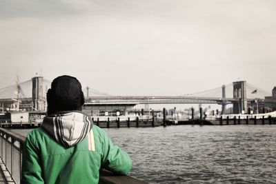 Rear view of man with suspension bridge in background