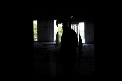 Silhouette man standing at entrance of building