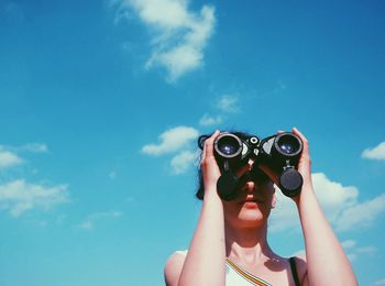 Low angle view of woman against blue sky