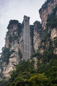 Low angle view of cross on mountain against sky