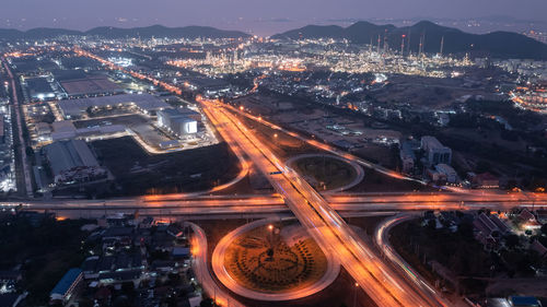 High angle view of illuminated street amidst buildings in city at night