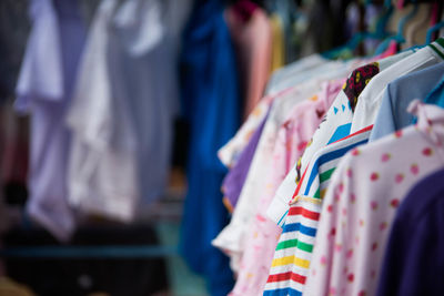 Close-up of clothes hanging in rack at store