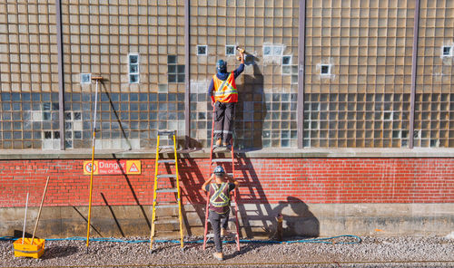 Rear view of men working on wall