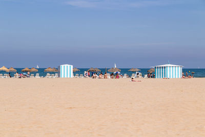 Group of people on beach against sky