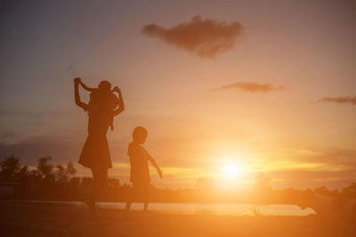 Silhouette people at observation point against sky during sunset