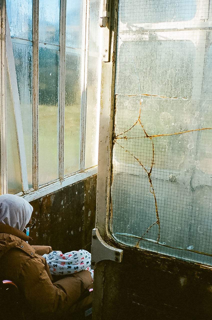 LOW SECTION OF MAN SITTING IN WINDOW