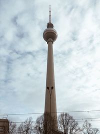 Low angle view of fernsehturm tower against cloudy sky
