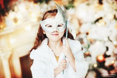 Portrait of young woman holding mask