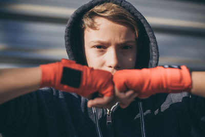 Portrait of boy in boxing glove standing outdoors
