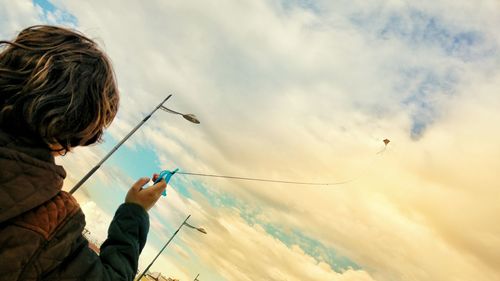 Low angle view of man fishing in sea