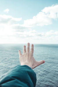 Midsection of person in sea against sky