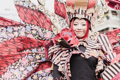 Portrait of a smiling young woman standing against graffiti