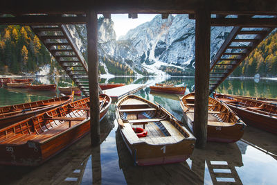 Boats moored in river with bridge in background