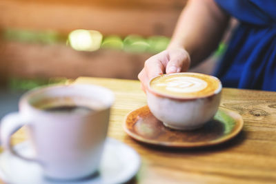 Midsection of coffee cup on table