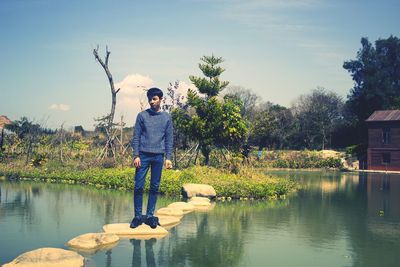 Full length of man standing by lake against sky