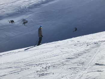 People skiing on snow covered landscape