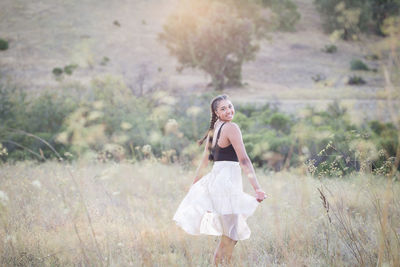 Portrait of smiling woman dancing on land