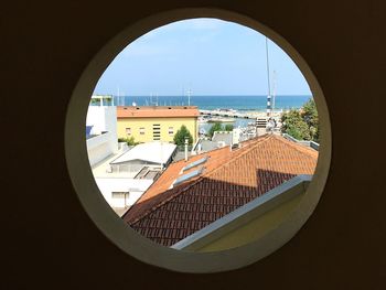 Sea against sky seen through window