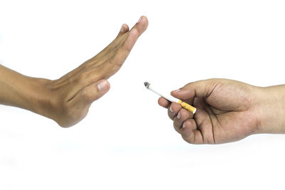 Close-up of man holding hands over white background