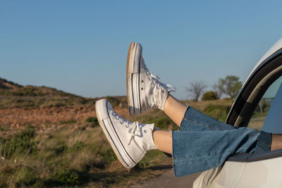 Low section of woman standing against sky