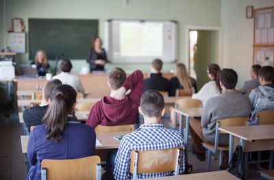 Rear view of students sitting in classroom