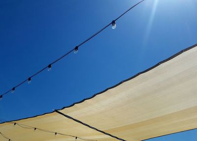 Low angle view of cables against clear blue sky