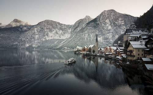 Scenic view of lake by snowcapped mountain against sky