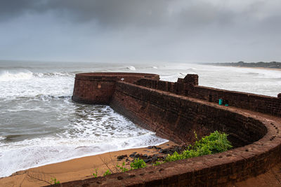 Candolim beach by fort aguada against sky